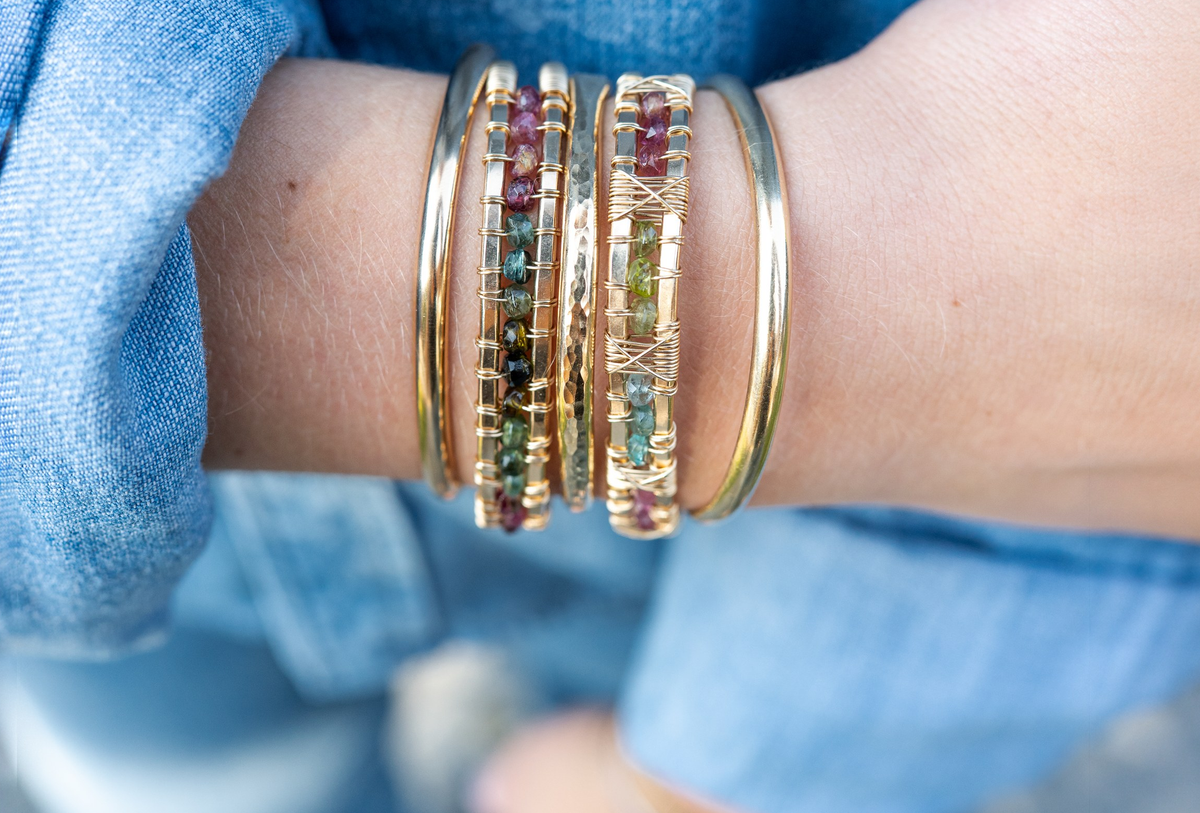 Tourmaline cuffs on a wrist against a denim sleeve